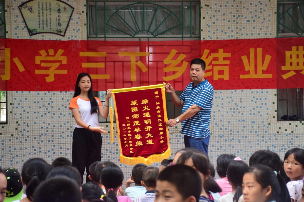 学校行知义教服务队与燎原小学互赠锦旗